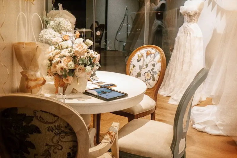 Intimate bridal consultation table with fresh flowers and wedding gown displays at Éclat Solairée atelier